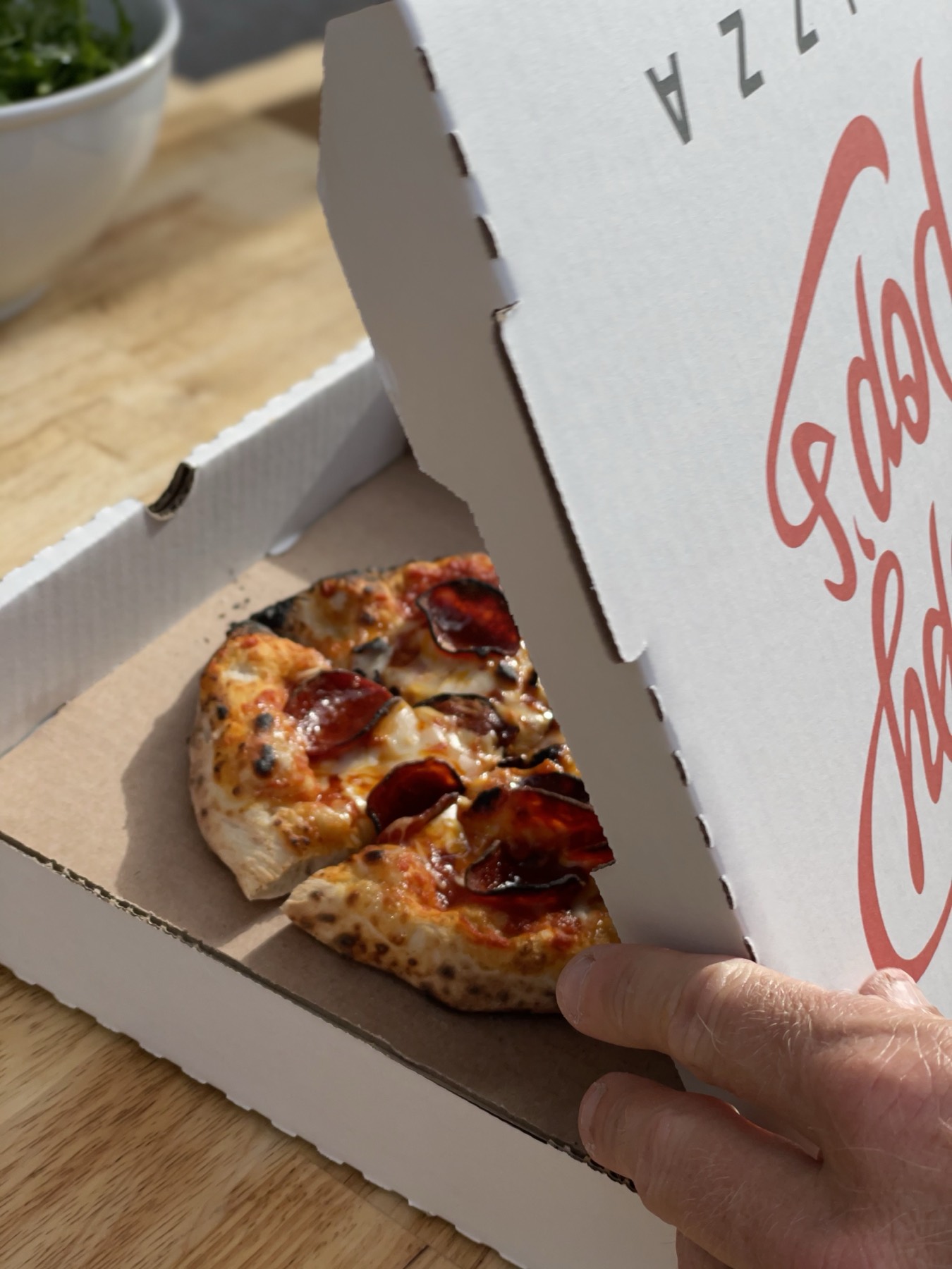 A box of wood-fired pepperoni pizza, fresh from the oven